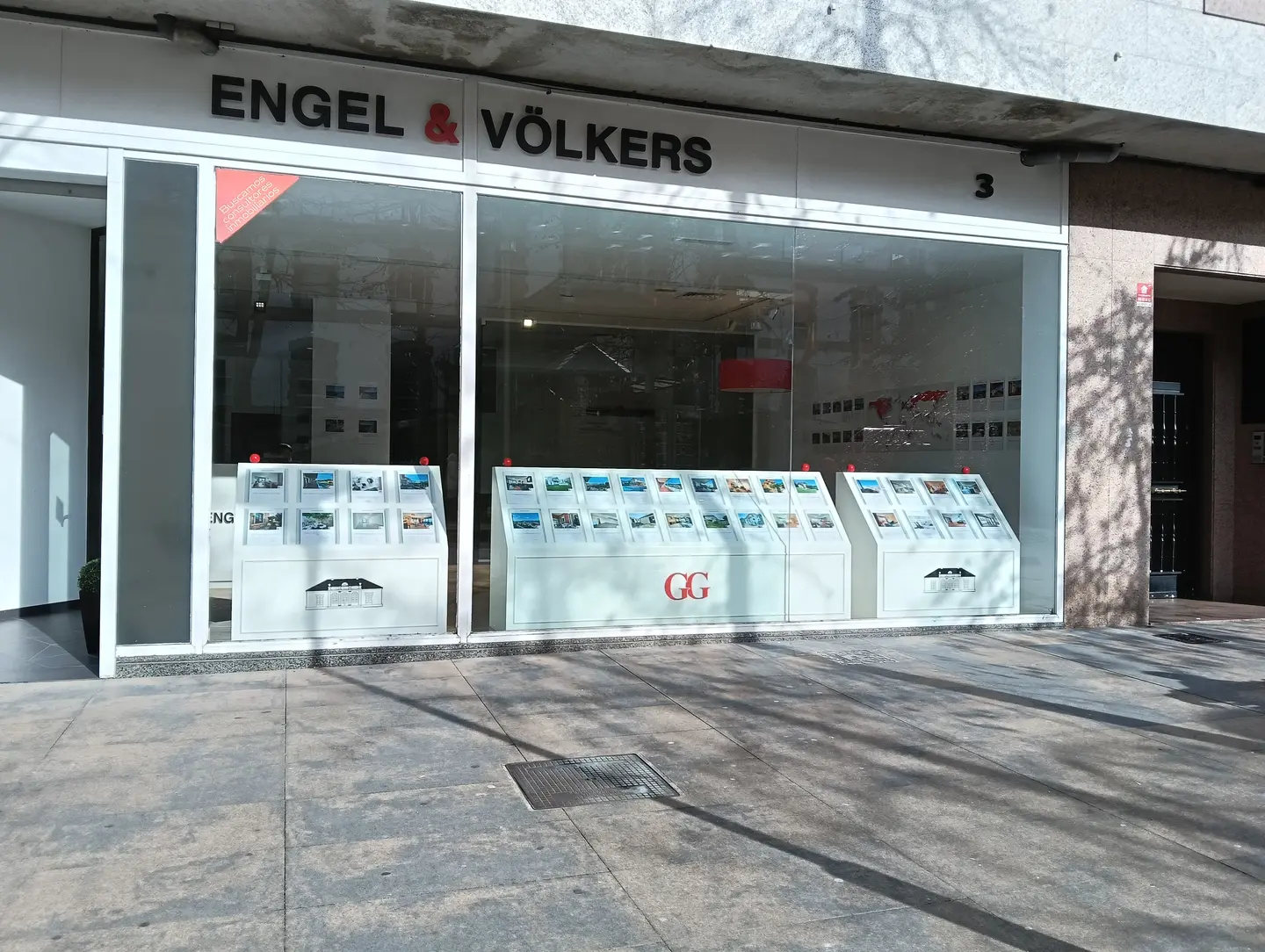 Engel & Völkers Immobilien-Schaufenster mit Immobilienangeboten im Fenster. Die Hausnummer ist 3.