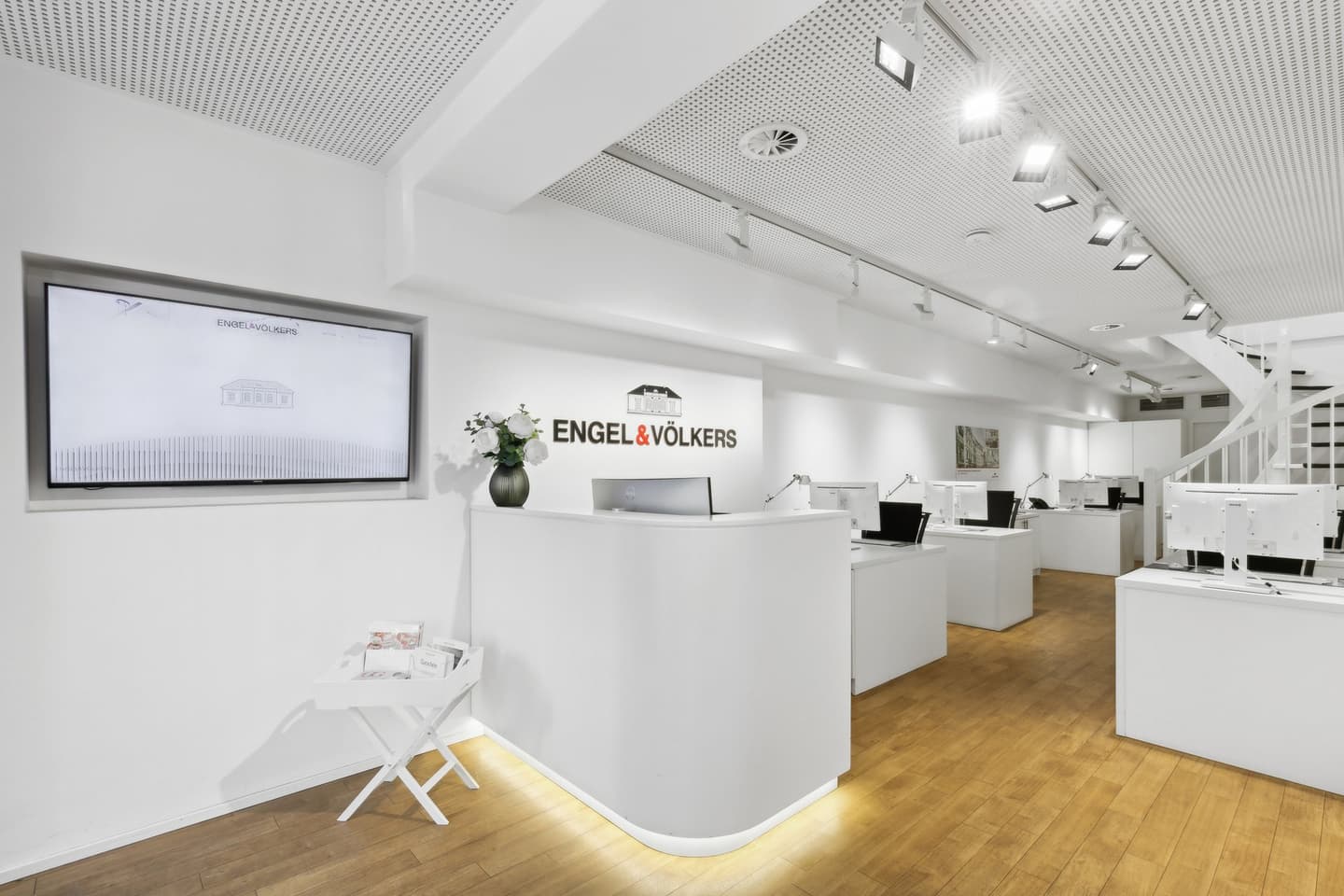 Engel & Völkers Immobilienbüro-Schaufenster mit Glasfenstern und schwarzen Türrahmen an einem Steingebäude.
