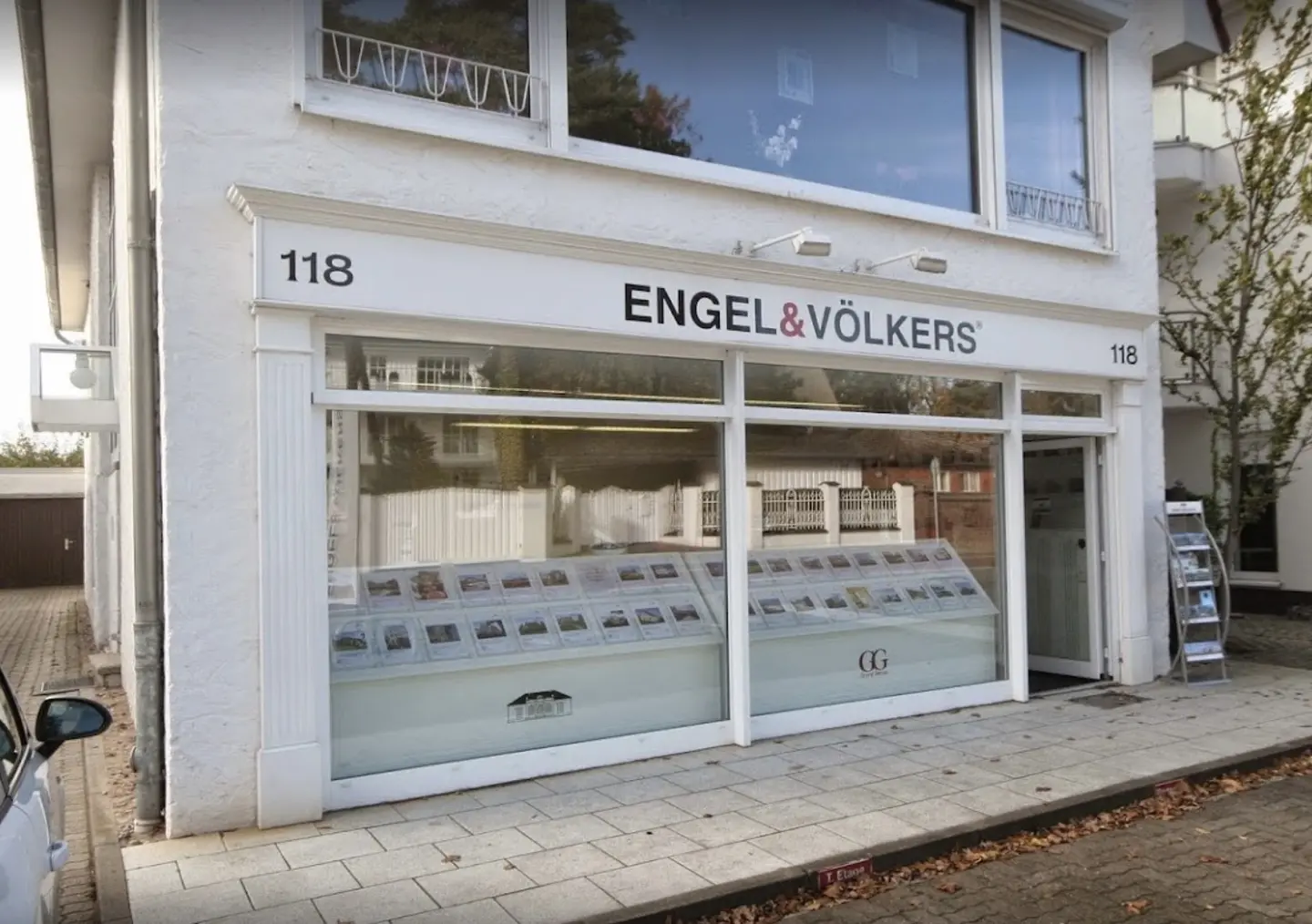 Exterior of Engel & Völkers real estate office at 118, with property listings displayed in the window.